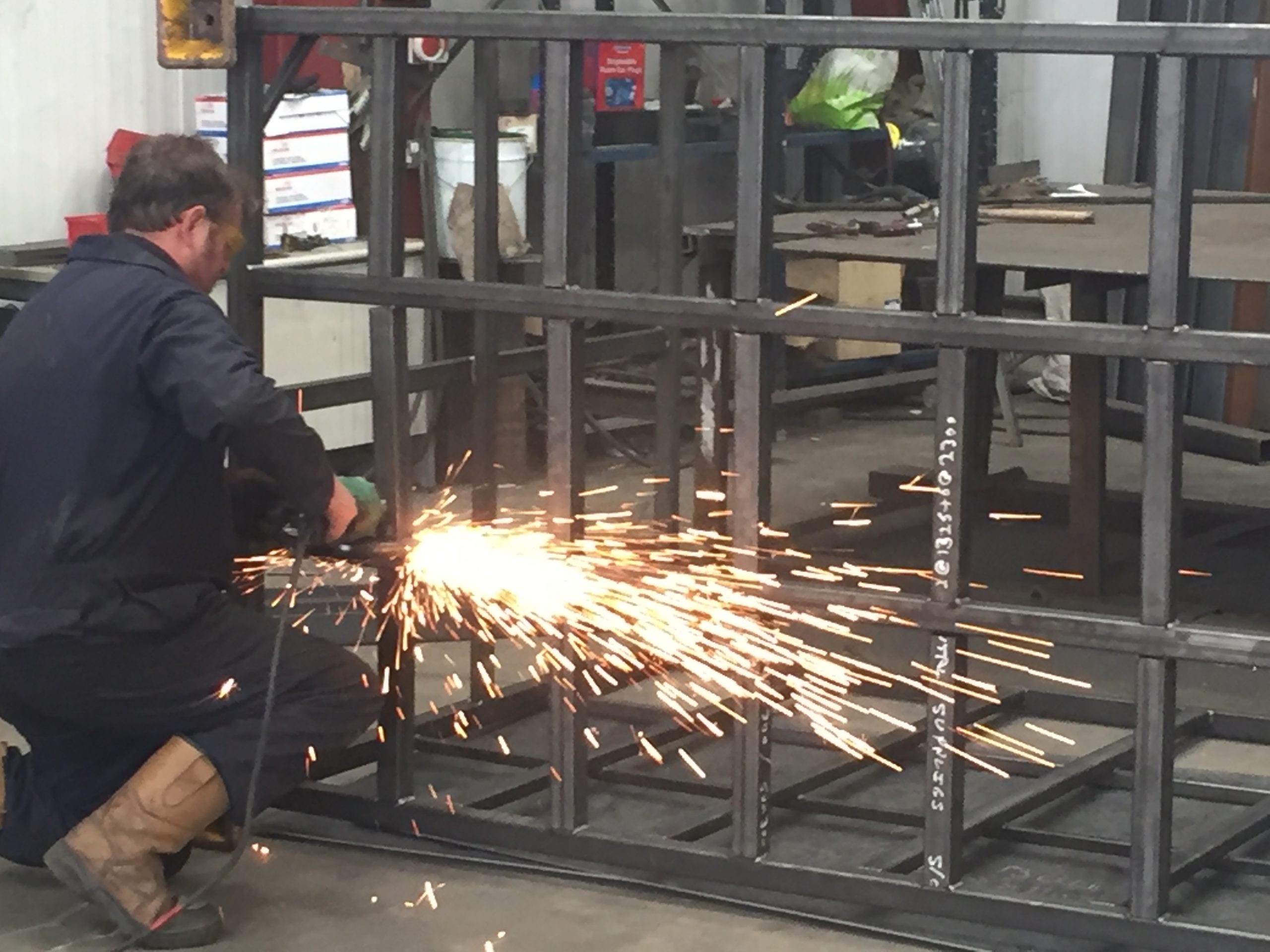 Steel fabricator grinding metal container